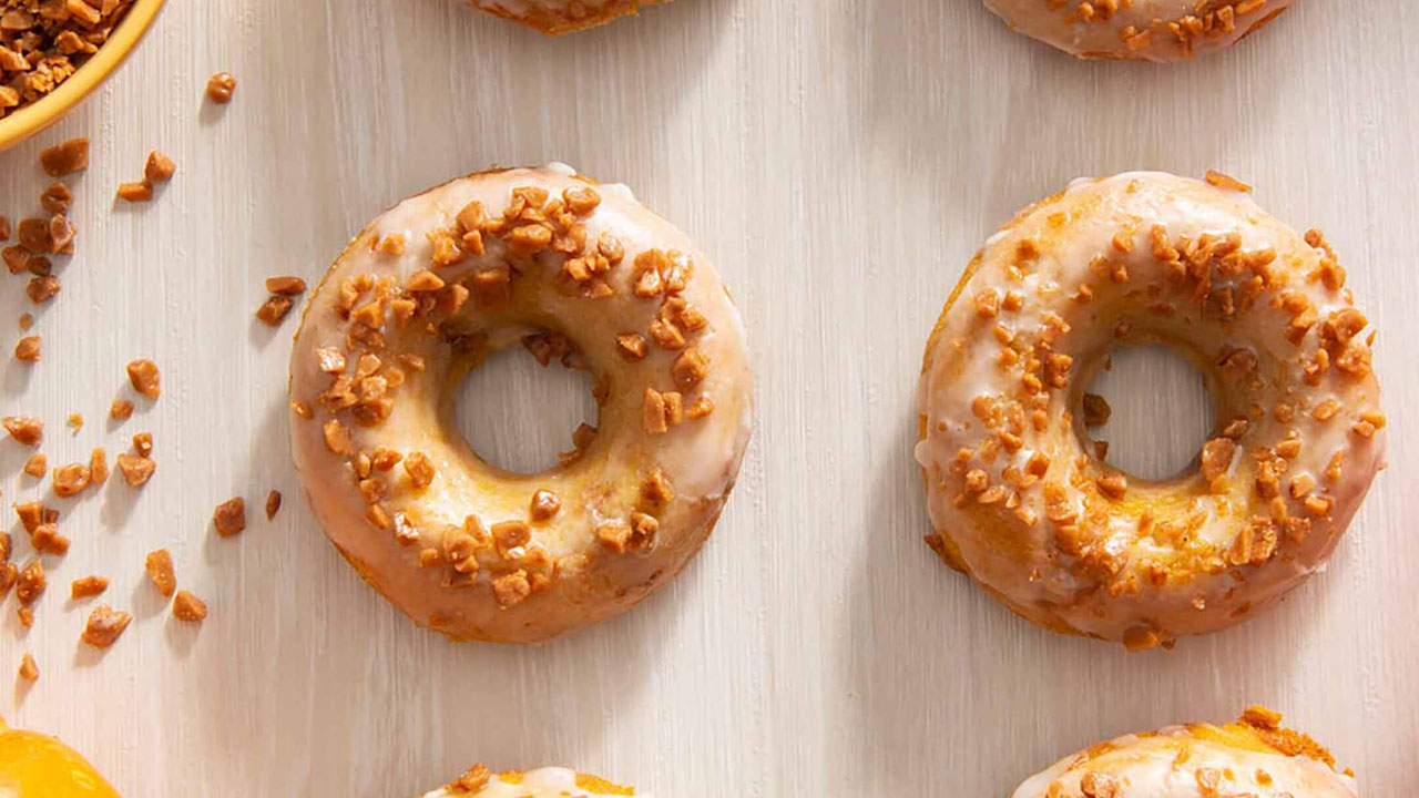 batch of freshly made baked pumpkin skor toffee donuts