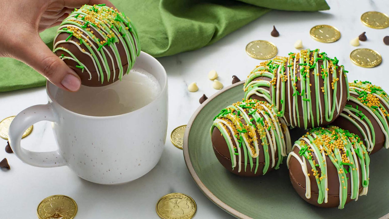 Assiette de bombes de chocolat chaud Hershey's en forme de trèfle à côté d'une tasse d'eau chaude